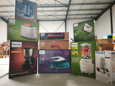 Plusieurs cartons contenant des appareils électroménagers sont empilés les uns sur les autres dans un entrepôt.