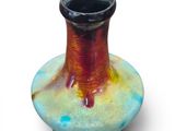 a vase that is sitting on a table with a white background