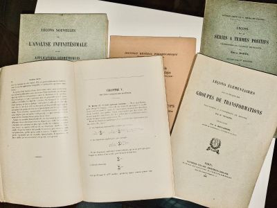 plusieurs livres ouverts posés sur une table, elle-même posée sur une autre table