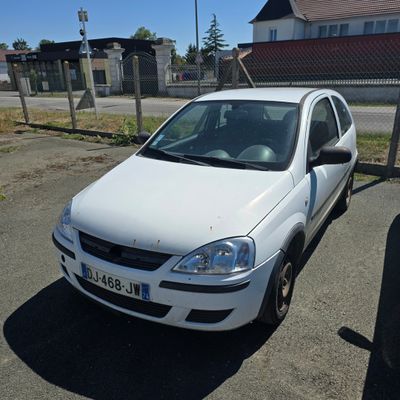 a white car parked in a parking lot next to a fence
