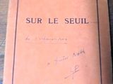 un livre posé sur une table, avec un stylo et du papier dessus