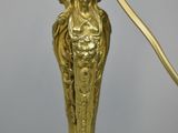 an antique brass table lamp with a glass shade on top of it
