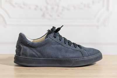navy blue sued sneakers with laces on a wooden table