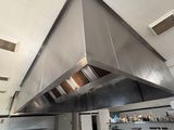 une grande hotte en acier inoxydable au milieu d'une cuisine