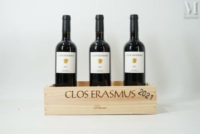 three bottles of red wine in a wooden crate on a white background