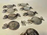 several pieces of silver jewelry sitting on top of a white surface