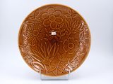 une assiette marron décorée de fleurs et de feuilles