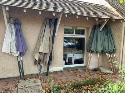 trois parapluies accrochés au mur d'un immeuble