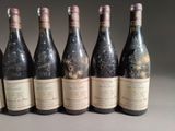 six bottles of wine are lined up in a row on a table