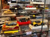 a glass display case filled with different types of toy cars