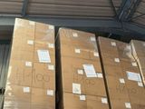 Les cartons sont empilés sur une palette dans un entrepôt doté d'une verrière.