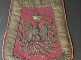 un vieux sac rouge et or brodé, orné d'un oiseau