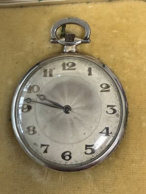 une montre de poche en argent accrochée au mur