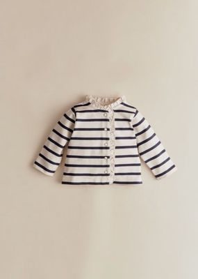 un gros plan d'une veste rayée blanche et noire accrochée à un mur