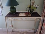 une petite table sur laquelle se trouvent une lampe et un livre