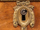 a close up of a wooden chest of drawers with a keyhole