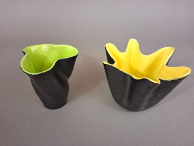 two black and yellow vases sitting on a table