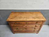 a small wooden chest of drawers on the floor