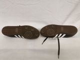 a pair of brown and white shoes on a white surface