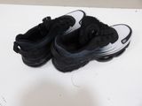 a pair of black and white shoes sitting on a table