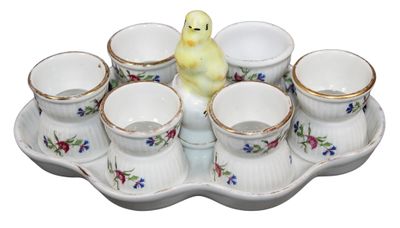a small yellow bird sitting on a tray with cups