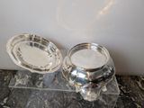 two silver dishes sitting on a marble counter top