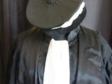a mannequin dressed in a black robe and a white tie