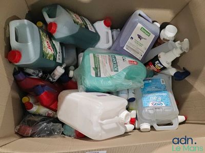 une boîte en carton remplie de produits d'entretien et d'autres articles ménagers