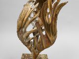 bronze sculpture of a fish on a stand with a cable