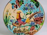 une assiette décorative sur laquelle sont peints un oiseau et des fleurs