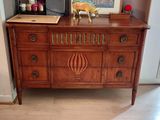 a wooden dresser with a painting on top of it