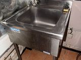 a stainless steel sink in the corner of a kitchen