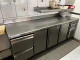 plan de travail en acier inoxydable dans une cuisine professionnelle équipée d'un lave-vaisselle