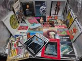 une valise remplie de livres et de magazines posée par terre