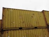 yellow shipping containers stacked on top of each other on a cloudy day