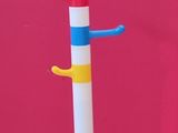 a multicolored toothbrush holder on a white stand