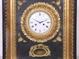 une horloge noire et dorée, avec un cadre doré