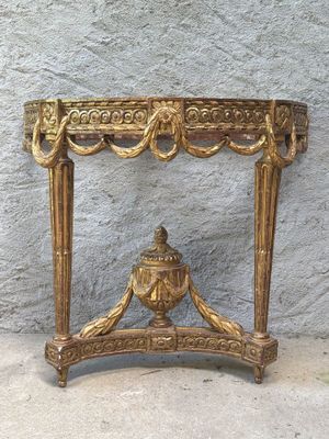 a gold table with a vase on top of it