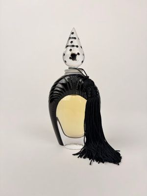une image représentant un flacon de parfum orné d'un pompon