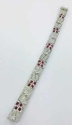 un gros plan d'un bracelet en argent orné de pierres rouges