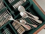 many silverware in a wooden box with a green cover