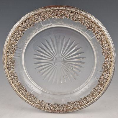 une assiette en verre ancienne ornée d'un motif circulaire sur le bord