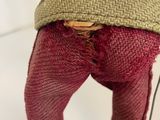 a doll that is wearing boots and a sweater