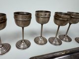 six silver goblets are lined up on a table