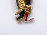 an image of a gold and black bird broochle on a white background