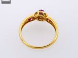 a close up of a gold ring with ruby stones on it