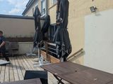 tables and chairs on a wooden deck with umbrellas on a sunny day