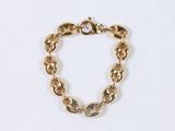 a close up of a gold chain bracelet on a white surface