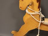 a wooden rocking horse with a rope on it