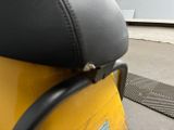 a yellow scooter with a black seat sitting on the ground